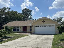 Inviting single-story home with a well-maintained lawn and a two-car garage under a blue sky at 6610 Pampus Dr, Orlando, FL 32819