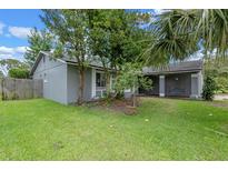 Side view of a grey home with a well manicured lawn and covered porch at 885 Little Bend Rd, Altamonte Springs, FL 32714