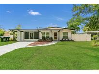 Charming single-story home with a green lawn, modern exterior, and curved walkway to the front door at 1208 Baltimore Dr, Orlando, FL 32810