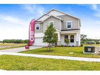Charming two-story home featuring a two-car garage, stone accents, and a well-manicured front lawn at 1262 Champions Dr, Daytona Beach, FL 32124