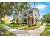 Charming townhome with a landscaped front yard, sidewalk, and inviting entryway, perfect for a modern Gathering at 12963 Garridan Ave, Windermere, FL 34786