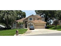 Charming two-story home with a well-manicured lawn, lush landscaping, and a spacious three-car garage at 1445 Valley Pine Cir, Apopka, FL 32712