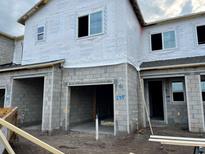 Unfinished townhouse exterior with concrete block and Tyvek wrap, showing garage and entrance at 14942 Harvest St, Orlando, FL 32824