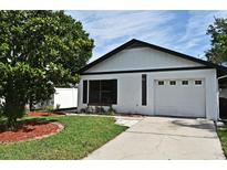 Charming home featuring a one-car garage, well-manicured lawn, and mature landscaping at 2524 Shadybranch Dr, Orlando, FL 32822