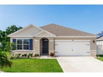Charming single-story home with a well-manicured lawn, lovely landscaping, and an attached two-car garage at 296 Inman Blvd, Winter Haven, FL 33881