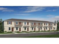 New townhome construction showing simple landscaping and neat front lawns with consistent neutral color scheme at 3060 Skyline Loop, Kissimmee, FL 34758