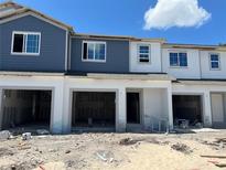 Charming townhome exterior featuring a blue and white color scheme, garage, and unfinished landscaping at 4248 Campsite Loop, Orlando, FL 32824