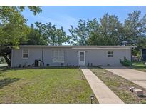 Charming single-story home featuring a well-maintained lawn and a classic brick facade at 985 N Village Dr, Deltona, FL 32725