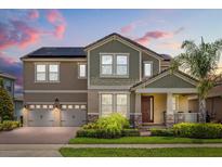 Stunning two-story home featuring a well-manicured lawn, a two-car garage, and solar panels for energy efficiency at 9873 Lost Creek Dr, Winter Garden, FL 34787