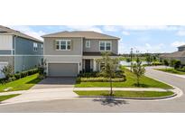 Charming two-story home with a well-manicured lawn, brick driveway and a view of the community pond at 13822 Destin Beach Ln, Orlando, FL 32827
