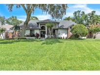 Charming home features a spacious front yard, stucco exterior, and mature landscaping at 1745 Seneca Blvd, Winter Springs, FL 32708
