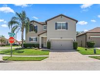 Charming two-story home with a well-maintained lawn, inviting curb appeal and a brick paved driveway at 2325 Bella Luna Cir, Lakeland, FL 33810