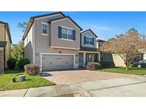 Charming two-story home with a brick driveway, attached two-car garage, and well-manicured landscaping at 2530 Domenico Paul Way Way, Orlando, FL 32810
