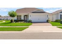 Charming single-Gathering home showcasing a lush front lawn, mature tree, and brick-paved driveway at 2793 Nature View Rd, St Cloud, FL 34771