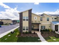 Modern townhome showcasing a two-story facade, landscaped yard, and convenient parking at 4184 Paragraph Dr, Kissimmee, FL 34746