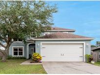 Charming two-story home featuring a two-car garage, well-maintained lawn, and mature trees at 4756 Fiske Cir, Orlando, FL 32826