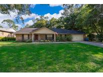 Charming brick home featuring a well-manicured lawn and a two-car garage at 493 Princewood Dr, Deland, FL 32724