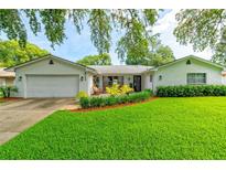 Charming single-story home featuring a well-manicured lawn and inviting front patio with lush landscaping at 4963 Hoperita St, Orlando, FL 32812