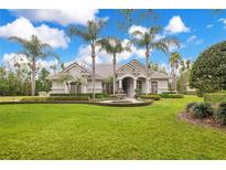 Stunning home featuring lush lawn, mature palms, circular driveway, and fountain at 5241 Vista Club Run, Sanford, FL 32771