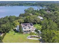 Stunning aerial view of lakeside home featuring manicured landscaping and modern solar panels at 5351 Carson St, St Cloud, FL 34771