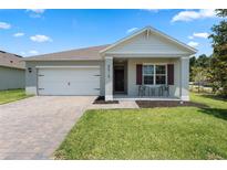 Charming single-story home featuring a two-car garage, manicured lawn and a cozy front porch at 5515 Palomino Pl, Apopka, FL 32712