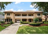 Charming two-story home featuring a tile roof, balcony, portico, and manicured front lawn at 6149 Blakeford Dr, Windermere, FL 34786