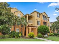 Attractive condo building showcasing well-maintained landscaping and classic architectural details under a blue sky at 6335 Contessa Dr # 208, Orlando, FL 32829