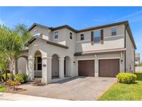 Stunning two-story home with a two-car garage, arched entrance, and beautifully landscaped front yard at 8348 Vivaro Isle Way, Windermere, FL 34786