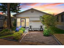 Charming single-story home featuring a well-manicured front yard, vibrant plants, and covered porch seating at 9000 Us Highway 192 # 115, Clermont, FL 34714