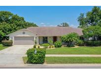 Charming single-story home with well-manicured landscaping, inviting curb appeal, and attached two-car garage at 957 Yellow Rose Dr, Orlando, FL 32818