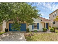 Charming single-story home featuring a well-maintained lawn and vibrant blue accents on the garage door and window shutters at 126 San Carlo Rd, Davenport, FL 33896