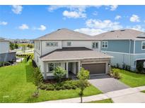 Two-story home boasts manicured lawn, stone accents, and a brick driveway, all under a sunny sky at 13323 Panama Beach Ct, Orlando, FL 32827