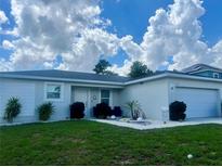 Charming single-story home with a well-manicured lawn and landscaped front yard at 1418 Kissimmee Ct, Kissimmee, FL 34759