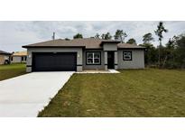 Beautiful single-story home featuring gray stucco, black trim, and a well-manicured lawn at 14990 Sw 29Th Ave Rd, Ocala, FL 34473