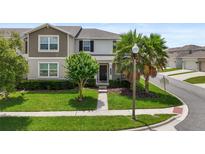 Charming two-story home featuring a well-maintained lawn and inviting landscaping, offering great curb appeal at 15096 Chapter Way, Winter Garden, FL 34787
