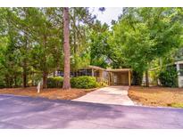 Charming single-story home with a covered carport nestled among lush green trees and landscaping at 203 N Forest Blvd, Lake Mary, FL 32746
