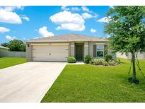 Charming single-story home featuring a well-maintained lawn, attached garage, and inviting entrance at 2668 Grand Central Ave, Tavares, FL 32778