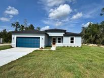 Charming single-story home with a blue garage door and freshly cut green lawn at 529 Marion Oaks Ln, Ocala, FL 34473