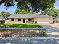 Charming single-story home with well-maintained lawn, brick accents, and a two-car garage at 5724 Pitch Pine Dr, Orlando, FL 32819