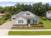 Beautiful single-story home featuring blue shutters and stone accents, surrounded by lush landscaping at 8080 Peaceful Cir, Sanford, FL 32771