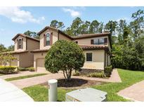Charming two-story villa with a tile roof, brick driveway, and manicured landscaping at 8219 Roseville Blvd, Davenport, FL 33896