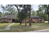Charming brick home featuring a well-maintained lawn, mature trees, and a cozy front entryway at 900 Red Fox Rd, Altamonte Springs, FL 32714