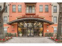 Welcoming entrance of Uptown Place showing glass doors, brick walkway, and neat landscaping at 911 N Orange Ave # 335, Orlando, FL 32801