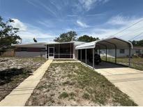 Charming single-story home featuring a carport and screened front porch at 1506 Carmen Ave, Daytona Beach, FL 32117