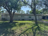 Charming single-story home featuring a well-maintained lawn and mature trees, exuding curb appeal and tranquility at 1526 Cordova Ave, Holly Hill, FL 32117