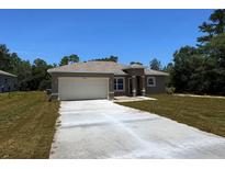 Beautiful single-story home with a two-car garage and a well-maintained front lawn, ideal for suburban living at 15380 Sw 60Th Cir, Ocala, FL 34473