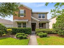 Inviting two-story home with manicured landscaping, stone accents, and a cozy front porch at 1978 J Lawson Blvd, Orlando, FL 32824