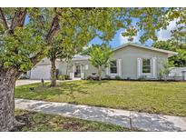 Charming single-story home boasts a well-manicured lawn, beautiful landscaping, and a welcoming front entrance at 2312 Poinciana Rd, Winter Park, FL 32792