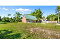 Charming single-Gathering home with a large yard, green metal roof, and bright blue door at 287 Hilltop Dr, Longwood, FL 32750