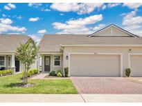 Inviting single story home featuring well-manicured lawn, paver driveway, and attached two-car garage at 3280 Canna Lily Pl, Clermont, FL 34711